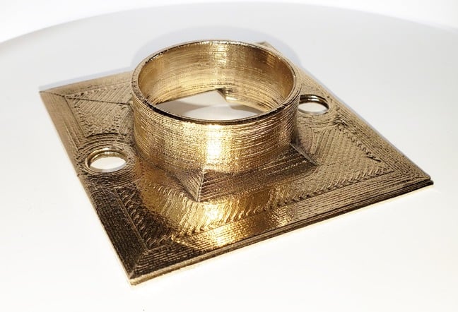 Metal Filament A brass candle holder on a white table.