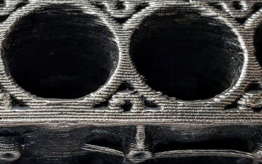 Close-up of a bronze-infused stainless steel 3D printed component, highlighting intricate details and textures relevant to liquid phase sintering in metal 3D printing.