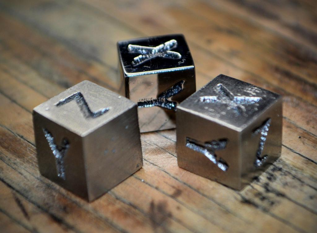 Metal 3D printing components showcasing engraved letters on metal cubes, emphasizing the application of metal filament technology in additive manufacturing.