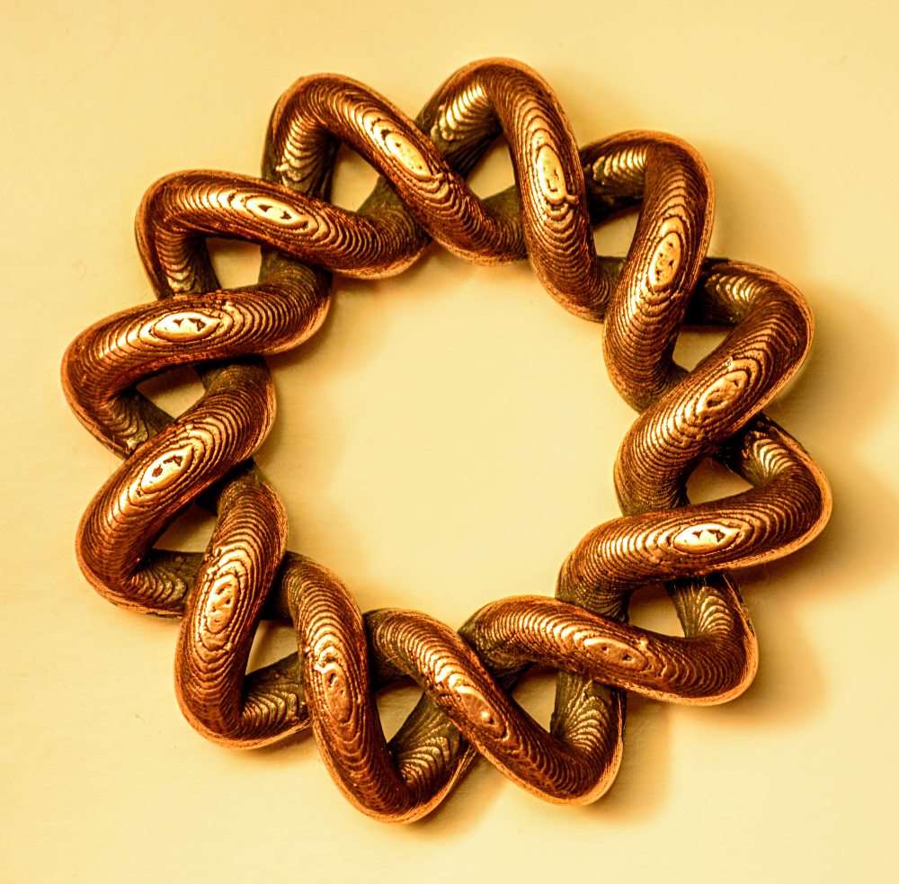 Copper broach design showcasing intricate twisted patterns, representing innovative FFF metal 3D printing technology by The Virtual Foundry.